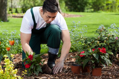 Hornchurch garden service worker checking tools and site safety